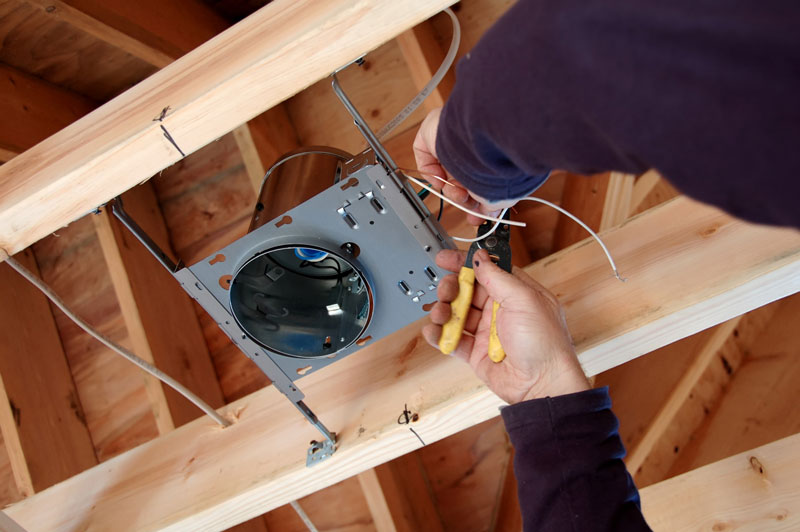 Electrician installing a fixture box in a new home